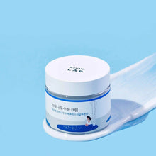 Skincare cream jar with a white lid on a blue background